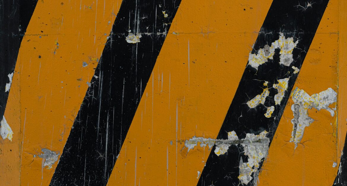 Worn yellow and black hazard stripes symbolizing warning signs of negligence