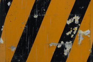 Worn yellow and black hazard stripes symbolizing warning signs of negligence