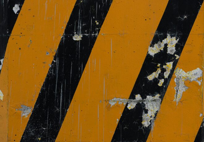 Worn yellow and black hazard stripes symbolizing warning signs of negligence